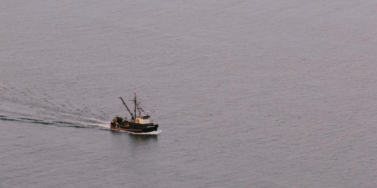 A commercial fishing boat heads out across open water.